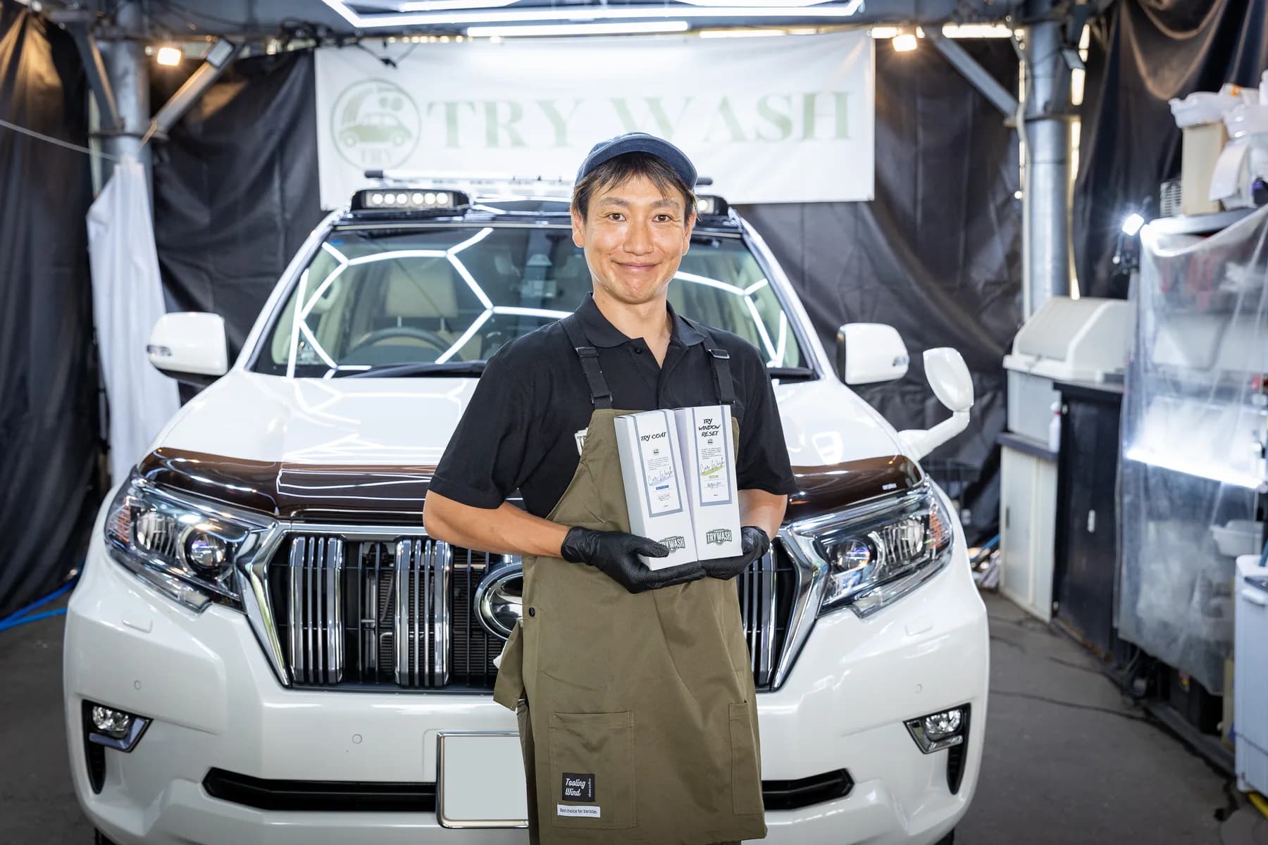 自社カーケア用品を手にするスタッフ